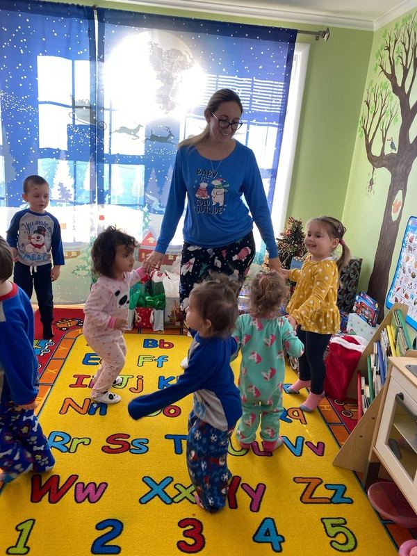 A teacher dancing with children in the classroom