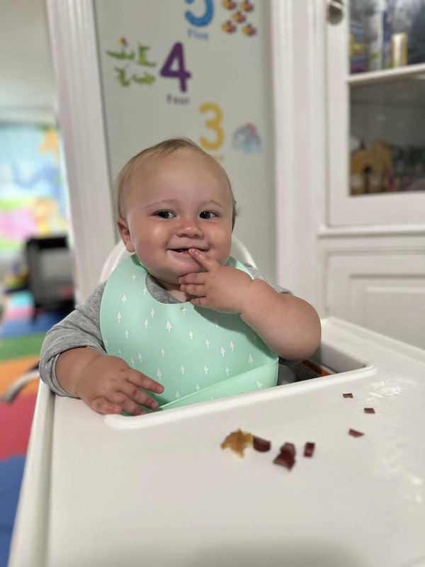 A baby enjoying a snack in a high chair