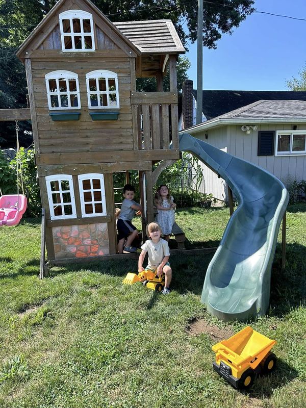 The playhouse and slide in the backyard