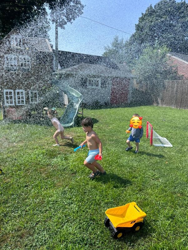 Children running through the sprinkler