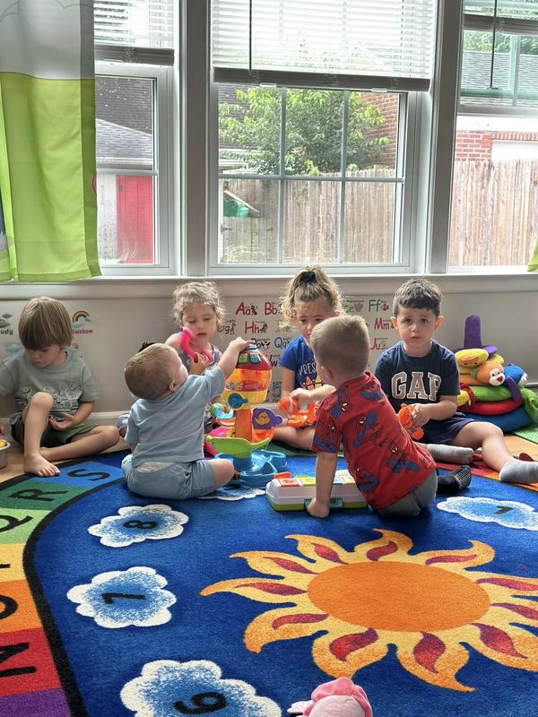 Children playing together on the sunshine rug