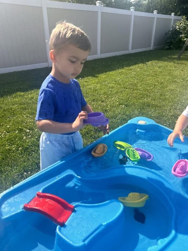 A boy playing at the water table