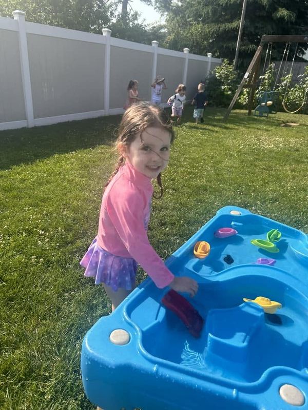 A girl playing at the water table