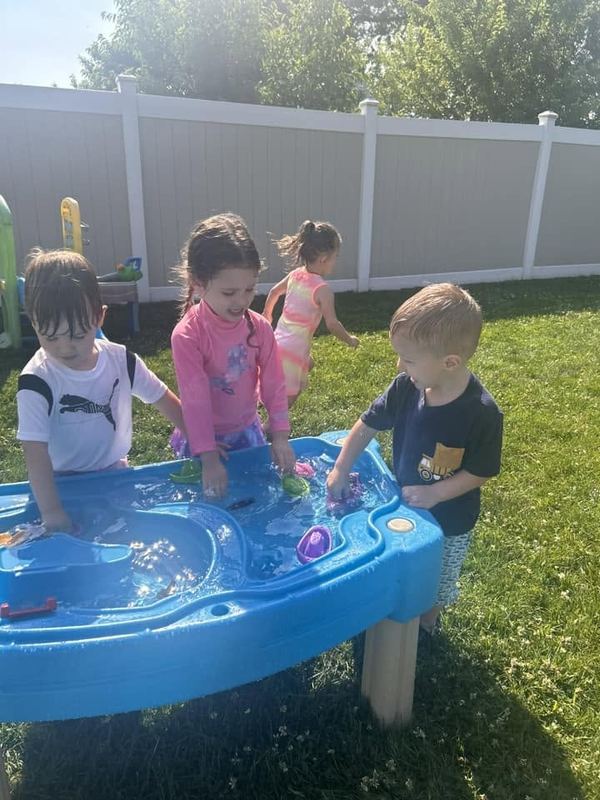 Children playing at the water table in the yard